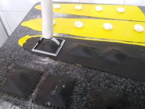 Ravioli bicolore allo zafferano e al nero di seppia con gamberi