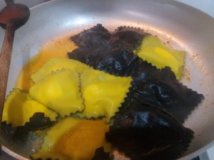 Ravioli bicolore allo zafferano e al nero di seppia con gamberi