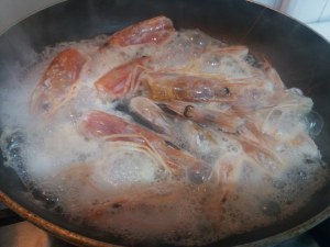 Ravioli bicolore allo zafferano e al nero di seppia con gamberi