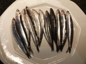 Alici marinate all'arancia su scarole con olive nere capperi pinoli e uva passa