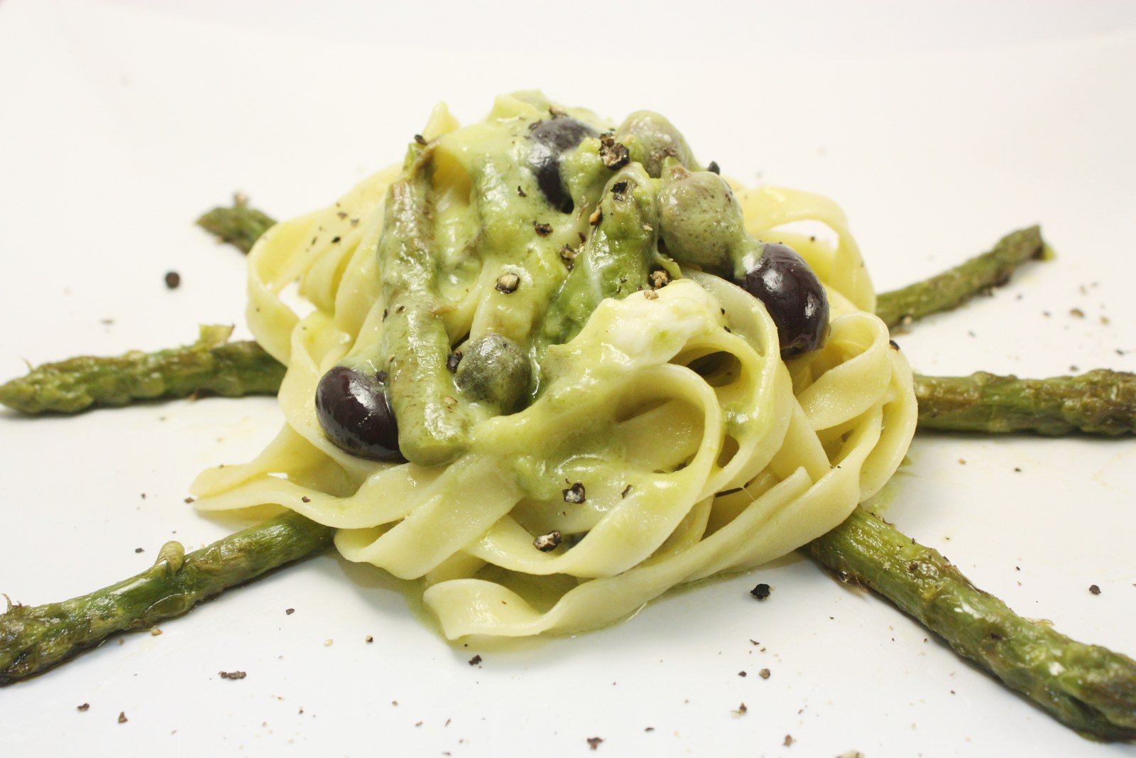 Tagliatelle con asparagi olive nere capperi e burrata di bufala