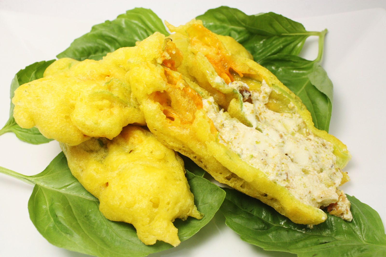 Fiori di zucca in pastella allo zafferano ripieni di ricotta di bufala provola e pesto di pistacchi