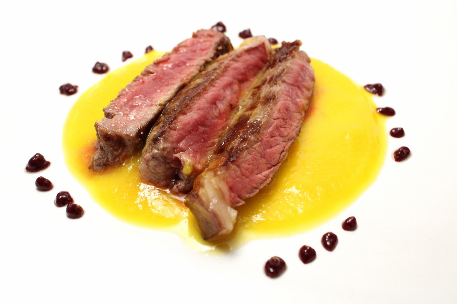 Tagliata di entrecote su coulis di peperone giallo con gocce di riduzione di aglianico