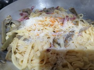 Tagliatelle profumate all'arancia con carciofi e speck su ricotta di bufala