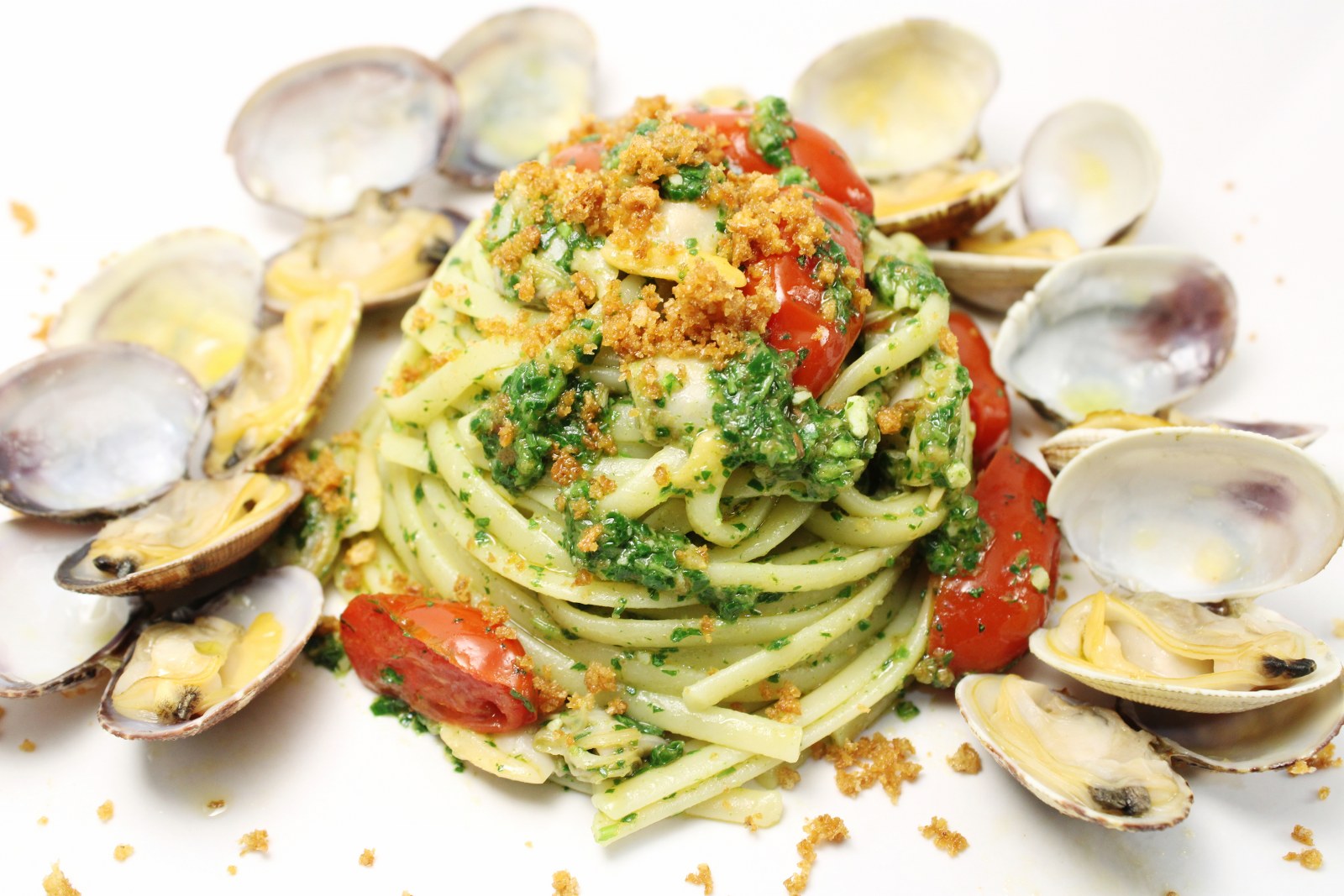 Linguine al pesto di rucola con datterini vongole e crumble di fresella di grano duro integrale