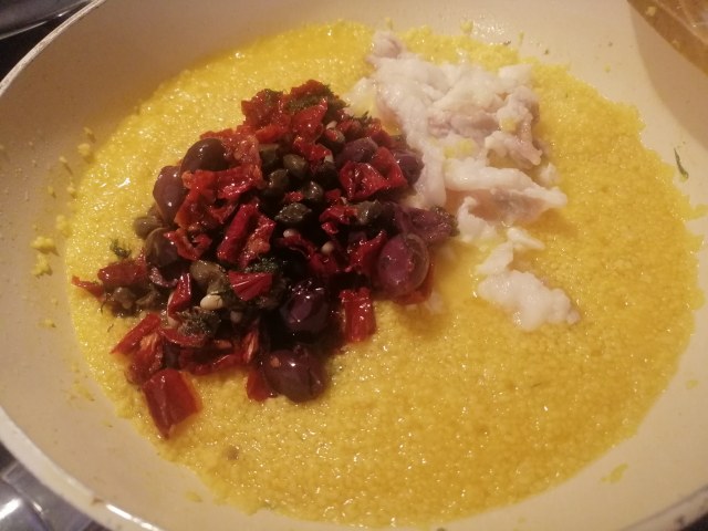 Cous cous allo zafferano con rana pescatrice pomodori secchi olive capperi pinoli e finocchietto selvatico