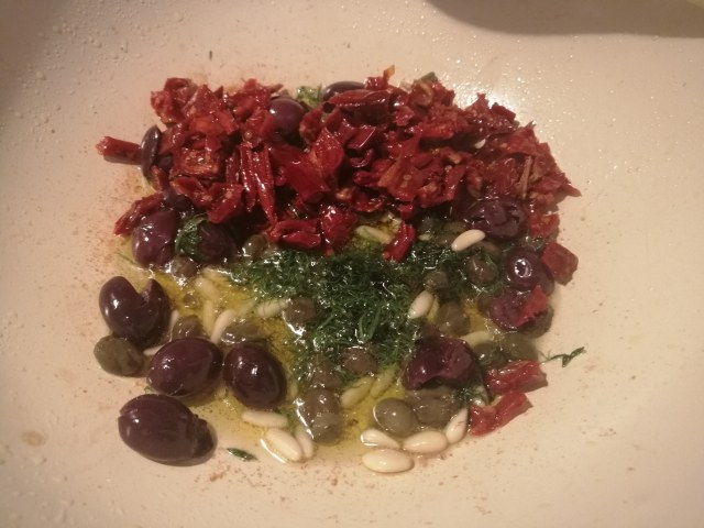 Cous cous allo zafferano con rana pescatrice pomodori secchi olive capperi pinoli e finocchietto selvatico