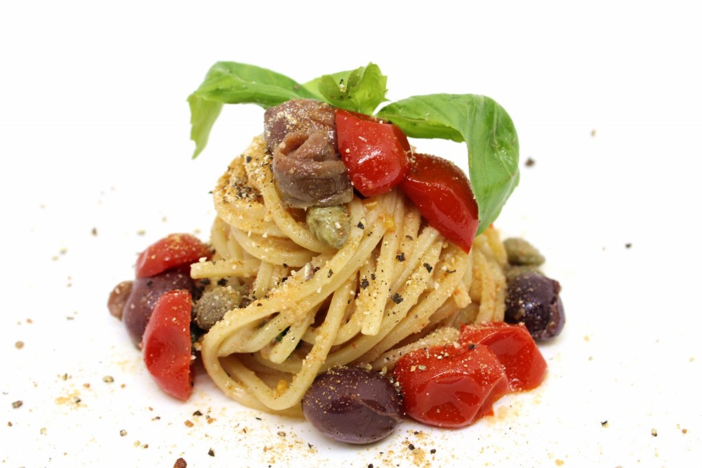 Spaghetti alla chitarra con datterini bottarga di tonno filetti di acciughe pinoli tostati olive nere capperi e pan grattato