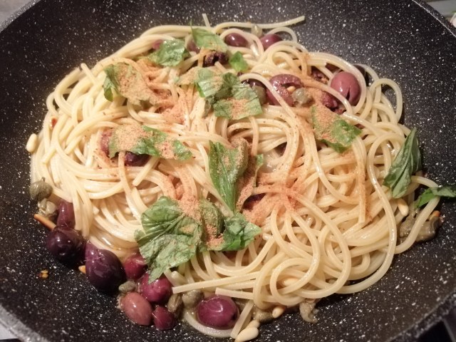 Spaghetti alla chitarra con datterini bottarga di tonno filetti di acciughe pinoli tostati olive nere capperi e pan grattato