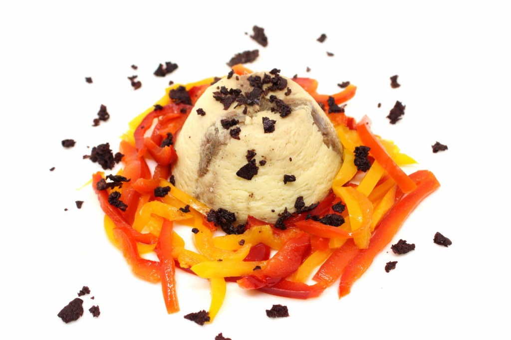 Flan di cavolfiore e acciughe con julienne di papaccelle sottaceto e terra di olive nere