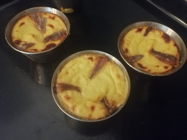 Flan di cavolfiore e acciughe con julienne di papaccelle sottaceto e terra di olive nere