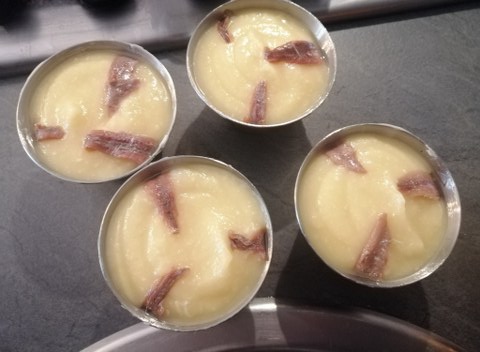 Flan di cavolfiore e acciughe con julienne di papaccelle sottaceto e terra di olive nere