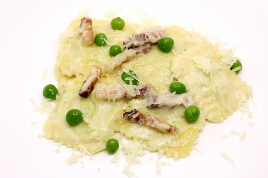 Ravioli ripieni di ricotta e piselli con crema di pecorino toscano e pancetta croccante