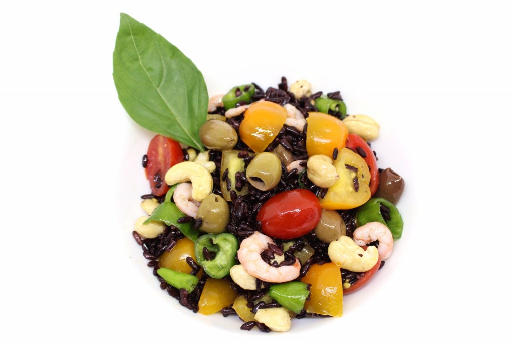 Insalata di riso nero con gamberetti peperoncini verdi olive taggiasche anacardi e datterini gialli e rossi