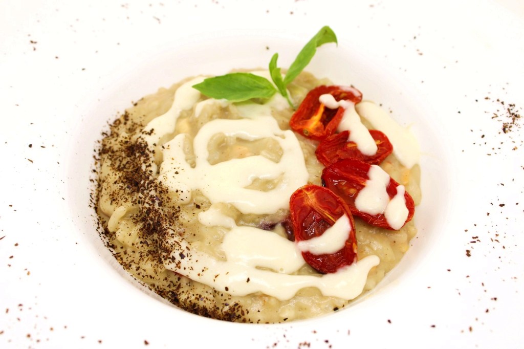 Risotto con crema di melanzana polvere delle sua buccia pomodorini semi dry provola e crema di parmigiano